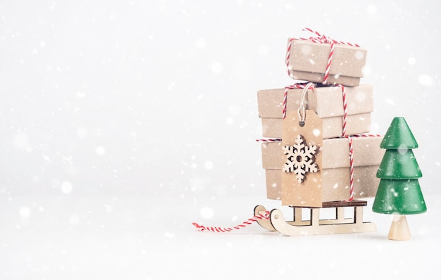 Boxes with gifts on a sled on a light background with space for\
text snow gifts for new year and christmas