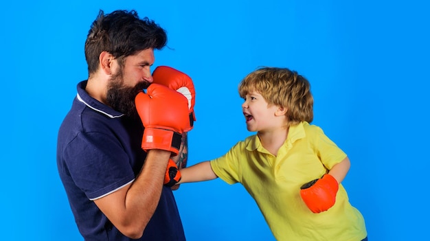 Boxing coach and kid training child in gloves learning boxing father and son ready for sparring