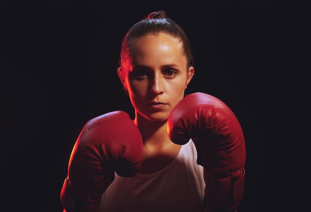 Photo boxing feminist fitness and sport with strong woman wearing boxing gloves for mma fight fitness and empower with black background fit boxer female and champion attitude for self defense and power