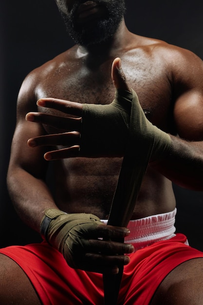 Boxing fighter putting on hand wraps