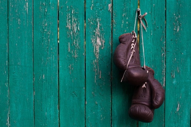 Boxing gloves hanging on old wooden wall