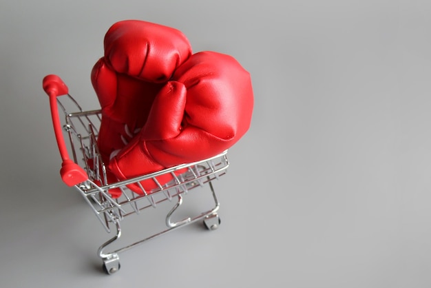 Boxing gloves inside shopping trolley with copy space Fight inflation concept