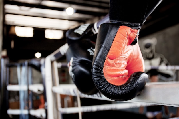 Boxing gloves is hanging on ring.