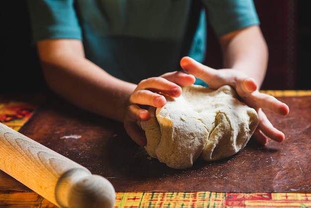 Boy 9 years old rolls out dough