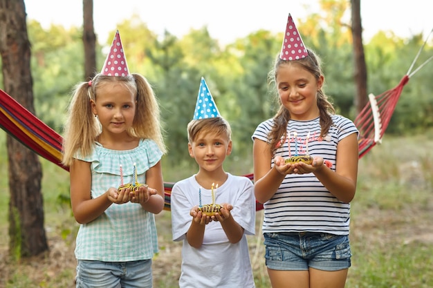 庭で屋外の誕生日を祝う男の子と女の子