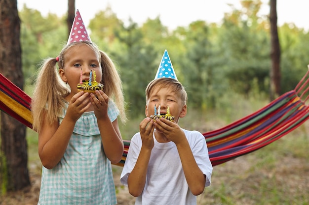 写真 庭で屋外の誕生日を祝う男の子と女の子