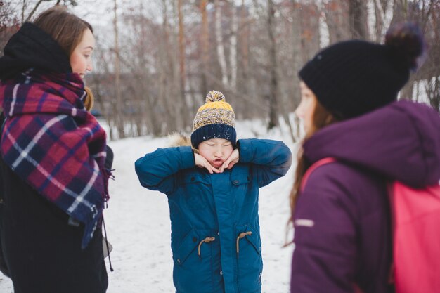 겨울 공원이나 숲에서 그의 가족과 함께 산책에 소년 장난