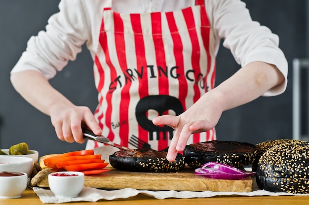 A boy in an apron cooking in the kitchen Burger.