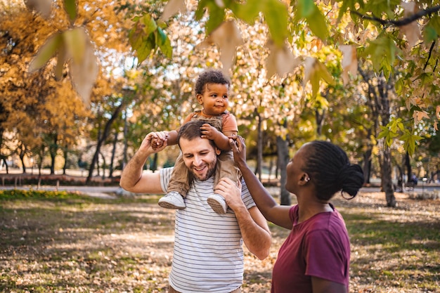 Boy in the arms of his parents in the park