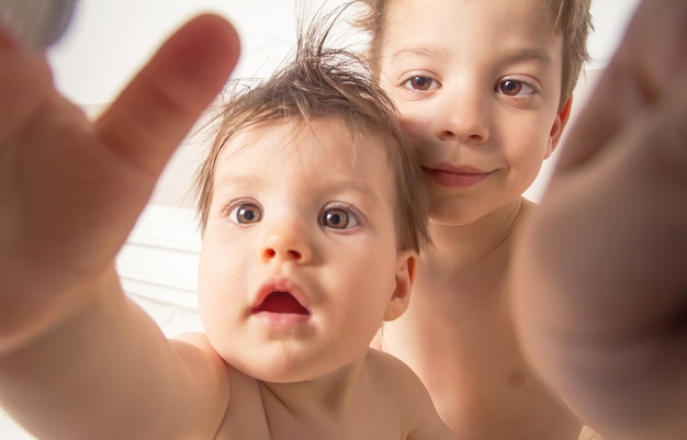 濡れた髪の男の子と赤ちゃんが自分撮り写真を撮る