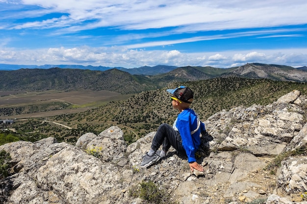 A boy on the background of the Black Sea and the Crimean mountains on the Golitsyn trail Crimea