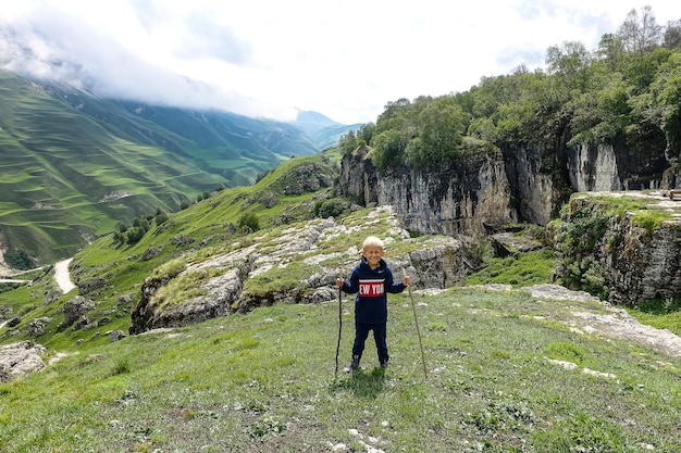 雲の中の山の風景を背景にした少年ダゲスタンロシアの石のボウル