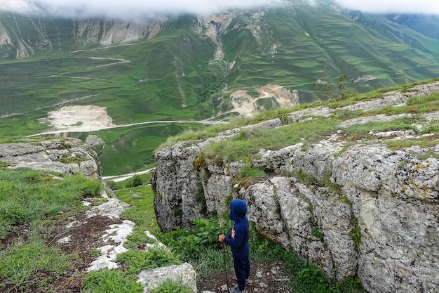 A boy on the background of a mountain landscape in the clouds Stone bowl in Dagestan Russia