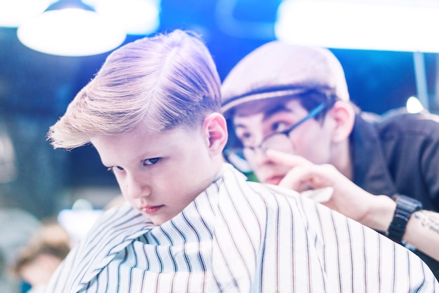 A boy in barbershop with a frowning look