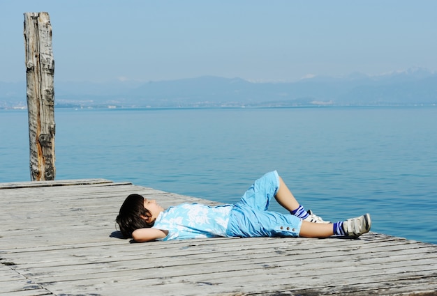 美しい湖のドックの少年