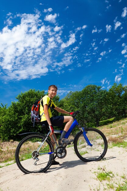 Ragazzo in bicicletta che viaggia nella foresta