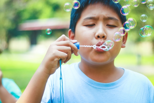 庭でシャボン玉を吹く少年