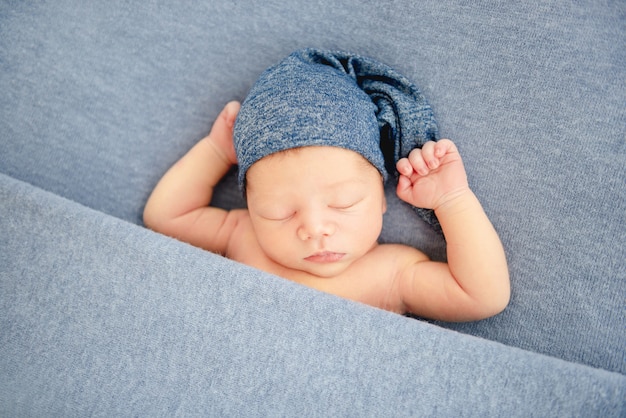 Boy in blue bonnet sleeping