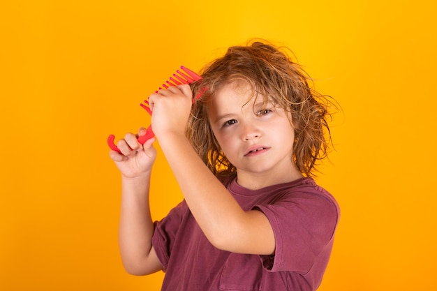 Boy brushes his hair child with brush combing hair boy taking hairstyle child brushing hair with comb kids haircare