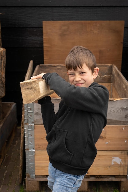 Boy builds a toy ship of wood child in the workshop makes\
crafts toy boat of wood