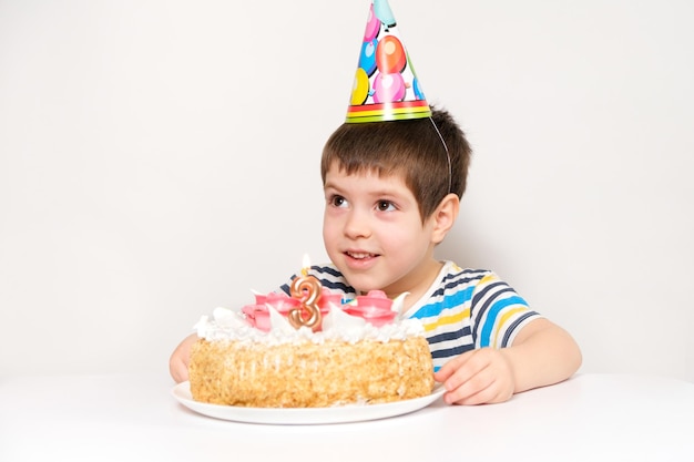 A boy and a cake with the number three, celebrates a birthday