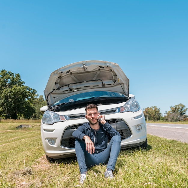 Foto ragazzo che chiama accanto all'automobile analizzata