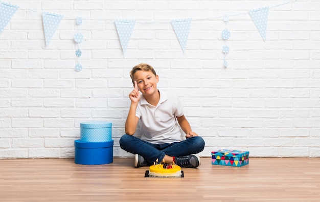 Boy celebrating his birthday with a cake counting number one sign