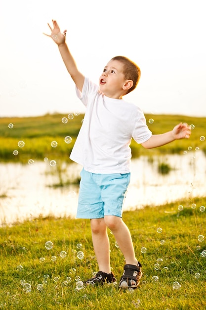 Photo boy chasing bubbles