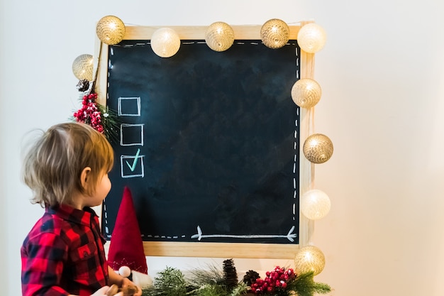 A boy checking options on a blackboard with copyspace