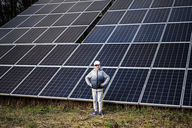 Boy child on the background of solar panels Eco energy