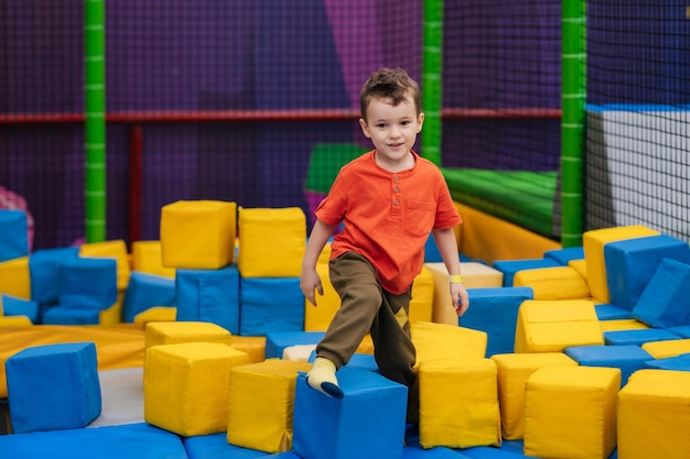 Foto un bambino sta giocando in un asilo nido di intrattenimento. gioca con grandi cubi morbidi passatempo attivo nel parco dei divertimenti