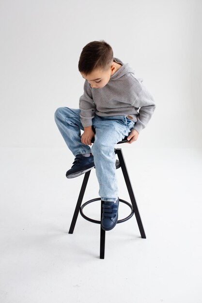 Boy child preschooler smiling and posing on gray background in photo studio