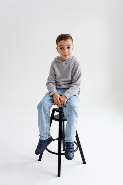 boy child preschooler smiling and posing on gray background in photo studio