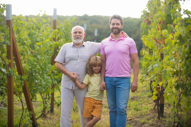 Boy child with father and old grandfather in garden farmer men farming and gardening on farm oncount