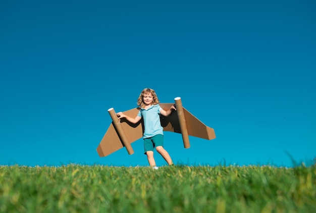 Boy child with wings at sky imagines a pilot and dreams of flying