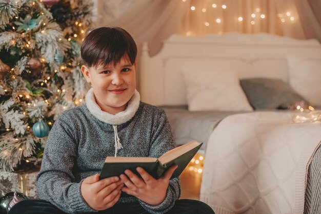 boy in christmas decorations reading book