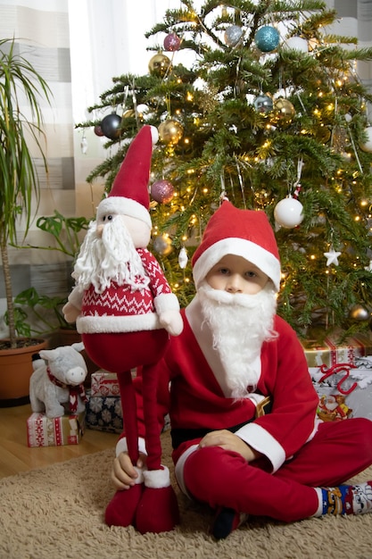 boy in Christmas pajamas boy against the background of a Christmas tree