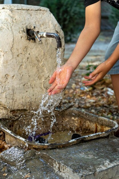 A boy cleaning his hand in a water