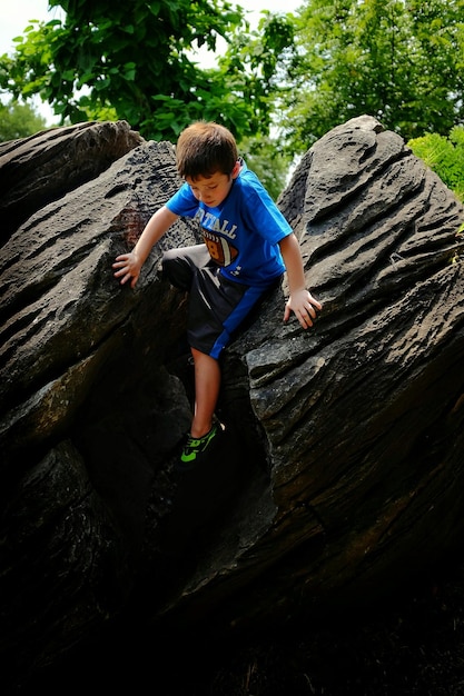 Photo boy climbing on rock