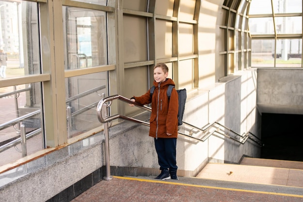 The boy comes out of the subway with a backpack