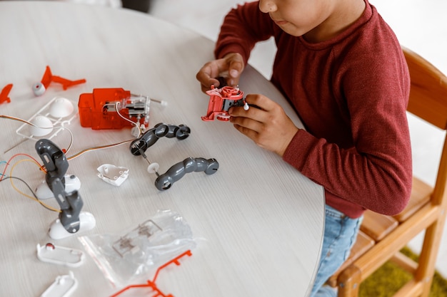 Boy constructing model with constructor details in school