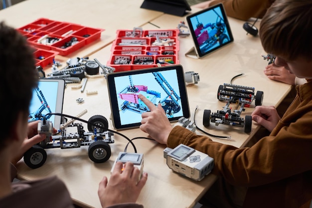 Foto ragazzo che controlla il suo robot con il computer