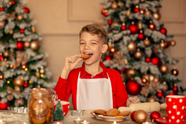 Boy cooking and eating Christmas cookies