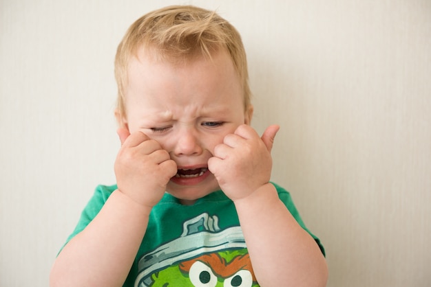 Boy crying covers her face with hands