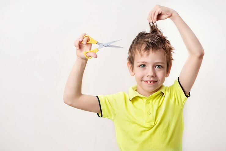 The boy cuts his own overgrown hair there is no way to go to the hairdresser because quarantine