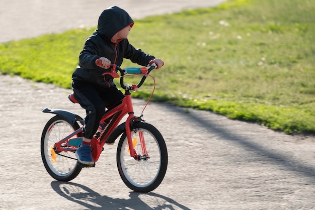 야외에서 자전거를 타는 소년. 아이는 자전거를 타는 법을 배웁니다.