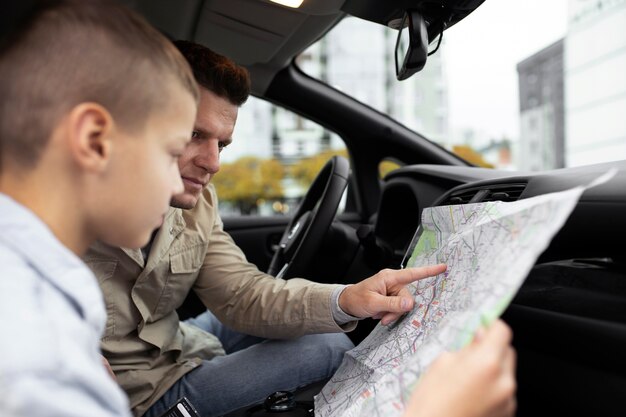 Foto ragazzo e papà vicino a un'auto elettrica