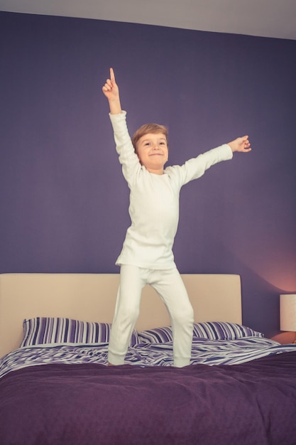 Boy dancing on bed at home