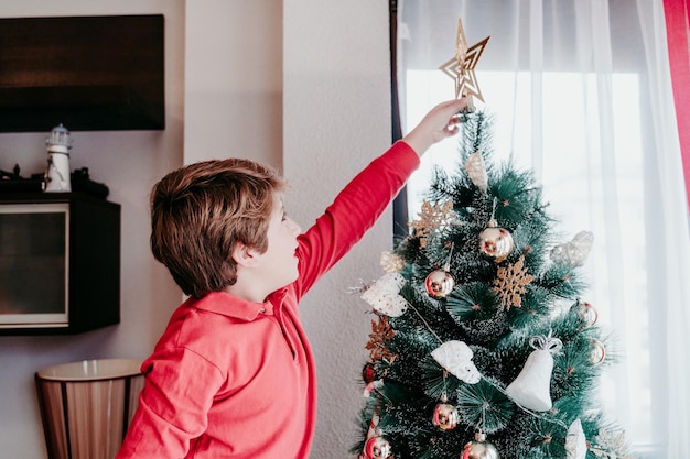 Photo boy decorating christmas tree