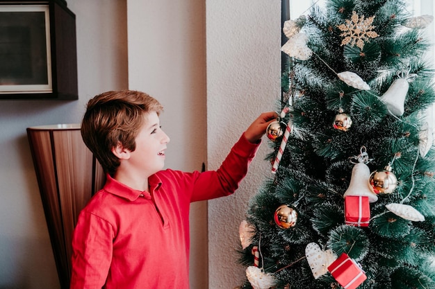 クリスマスツリーを飾っている少年